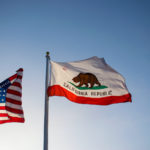 Photo of California Flag next to American flag