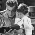 Portrait of dad reading bedtime story to son